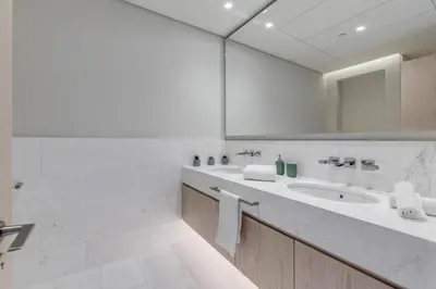 a white bathroom with a sink and a mirror at Luxury Palm Tower Studio Apartments with Pool and Fantastic Sea View in Dubai