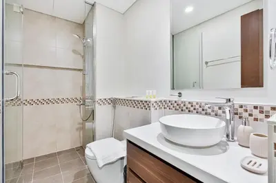 a white bathroom with a sink and a shower at Amazing 1BR APT with Burj Khalifa Views in Dubai