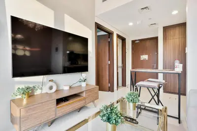 a living room with a large television on a wall at Amazing 1BR APT with Burj Khalifa Views in Dubai
