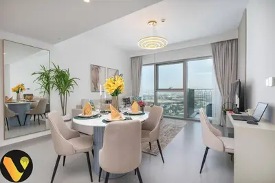 a dining room and living room with a table and chairs at Vogue Downtown Views II with Direct Access to Dubai Mall Via a Climate Controlled Bridge, One Bedroom Apartment with Balcony and City View in Dubai