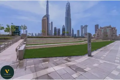 a park with benches and a view of a city at Vogue Downtown Views II with Direct Access to Dubai Mall Via a Climate Controlled Bridge, One Bedroom Apartment with Balcony and City View in Dubai