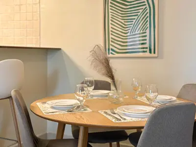 a wooden table with plates and wine glasses on it at Near Metro & Tram 2bed Dubai Marina Close To Jbr! in Dubai
