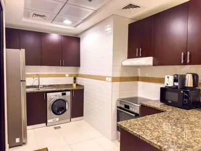 a kitchen with a washing machine and a washer at 1BHK in Business Bay near metro in Dubai