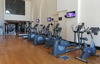 a gym with several rows of tread machines in a room at Upgraded 1BR Retreat with Iconic Burj Khalifa Views in Dubai