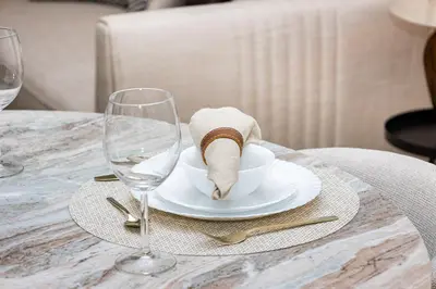 a table with a plate with a napkin and two wine glasses at Upgraded 1BR Retreat with Iconic Burj Khalifa Views in Dubai