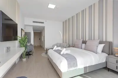 a bedroom with a large bed and a living room at Perfect Getaway modern Studio in Luma 22 - JVC in Dubai