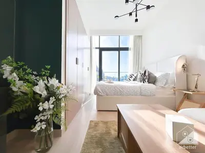 a bedroom with a bed and a vase of flowers at Bright Studio in Azizi Riviera Perfect City Escape in Dubai
