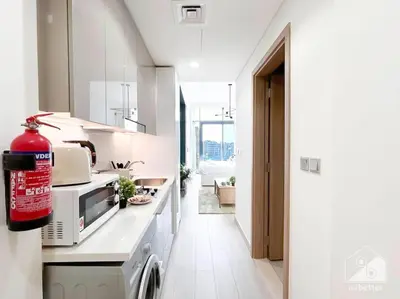 a white kitchen with a washing machine in it at Bright Studio in Azizi Riviera Perfect City Escape in Dubai