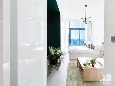 two views of a bedroom and a living room at Bright Studio in Azizi Riviera Perfect City Escape in Dubai