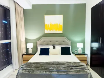 a bedroom with a large bed and two lamps at Luxury apartment in Business bay 5 people in Dubai