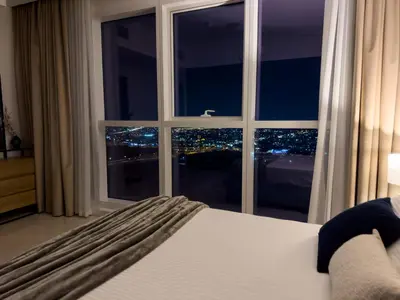 a bedroom with a large window with a city view at Luxury apartment in Business bay 5 people in Dubai
