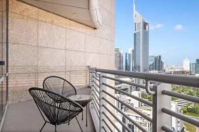 a balcony with two chairs and a view of a city at Silkhaus Sky Gardens Chic Studio in DIFC Living in Dubai