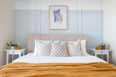 a bedroom with a large bed with two white tables at Silkhaus Comfort Studio at Sky gardens-DIFC in Dubai