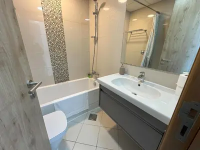 a bathroom with a sink and a tub and a toilet at SUNRISE HOMES - 2 BR with Panoramic Marina Views in Dubai