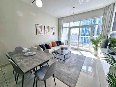a living room with a table and a couch at SUNRISE HOMES - 2 BR with Panoramic Marina Views in Dubai