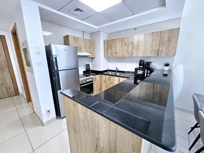 a kitchen with wooden cabinets and a stainless steel refrigerator at SUNRISE HOMES - 2 BR with Panoramic Marina Views in Dubai
