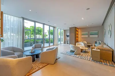a living room with chairs and tables and windows at Lux 2 King Bed Suite - Grande Signature Residences in Dubai
