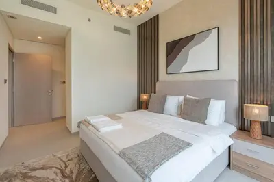 a bedroom with a large bed and a chandelier at Lux 2 King Bed Suite - Grande Signature Residences in Dubai