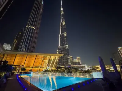 a swimming pool in front of a city at night at Lux 2 King Bed Suite - Grande Signature Residences in Dubai
