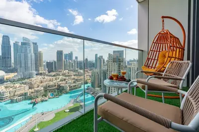 a balcony with chairs and a table and a view of the city at Lux 2 King Bed Suite - Grande Signature Residences in Dubai