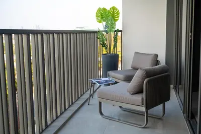 a balcony with two chairs and a table and a plant at Spacious Unit With Burj Khalifa View in Dubai