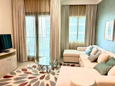 a living room with a couch and a tv at 1BHK in Damac Masion mall street in Dubai