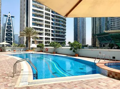 a swimming pool on the roof of a building with tall buildings at Next to METRO 1BED with Panoramic Lake View in Dubai