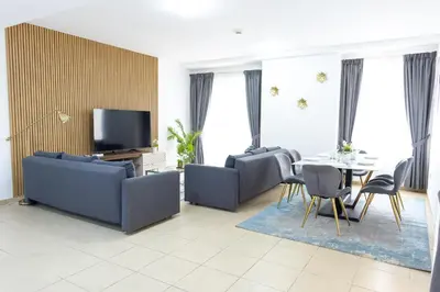 a living room with two couches and a table and a tv at HAPPY SEASON JBR apartments in Dubai