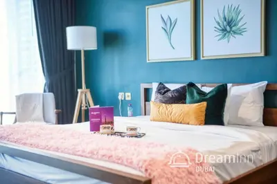 a bedroom with blue walls and a bed with pillows at Dream Inn - Damac Heights Fendi in Dubai