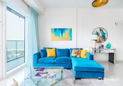 a blue couch in a living room with a window at Dream Inn - Damac Heights Fendi in Dubai