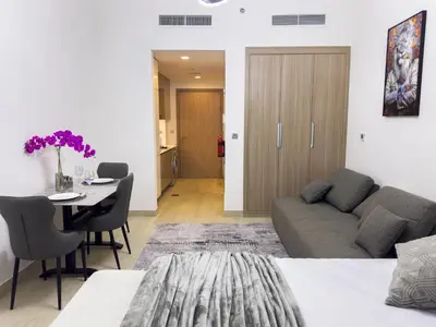 a living room with a couch and a table at Furnished Studio Azizi Riviera 3 in Dubai
