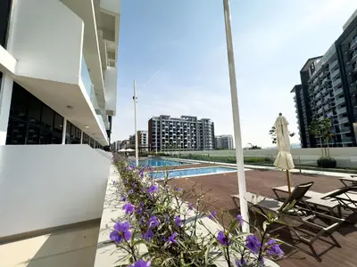 a view from the balcony of a building with purple flowers at Furnished Studio Azizi Riviera 3 in Dubai