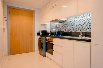 a kitchen with a stove and a sink and a dishwasher at NEW Cozy & Stylish APT with Pool & Gym Access in Dubai