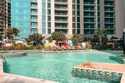 a large swimming pool in front of a tall building at NEW Cozy & Stylish APT with Pool & Gym Access in Dubai