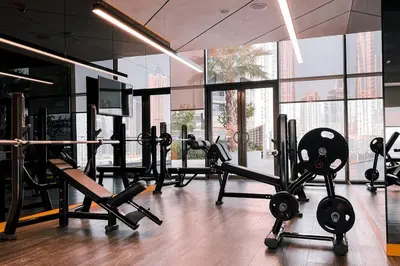 a gym with a lot of treadmills and machines at NEW Cozy & Stylish APT with Pool & Gym Access in Dubai