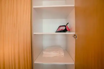 a white closet with a towel and a red purse at NEW Cozy & Stylish APT with Pool & Gym Access in Dubai