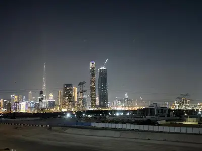a city skyline at night with tall buildings at Studio in Azizi Riviera Dubai in Dubai