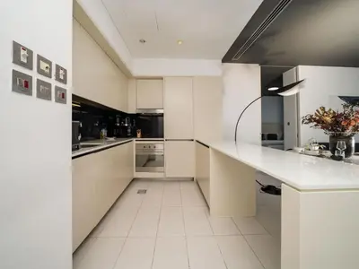 a white kitchen with a large white counter top at Luxury 1-Bed DIFC Stay - City Views in a Prime Area in Dubai