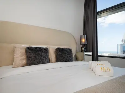 a bedroom with a white bed with a large window at Luxury 1-Bed DIFC Stay - City Views in a Prime Area in Dubai