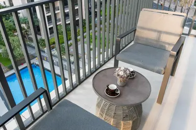 a balcony with a table and a chair and a pool at Downtown Luxury Treat - Premium Location! 2 bedroom! in Dubai