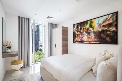 a white bedroom with a large tv on the wall at Downtown Luxury Treat - Premium Location! 2 bedroom! in Dubai