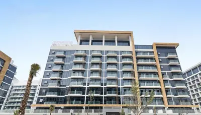 a tall building with palm trees in front of it at Vacay Lettings Charming Retreat Azizi Riviera in Dubai