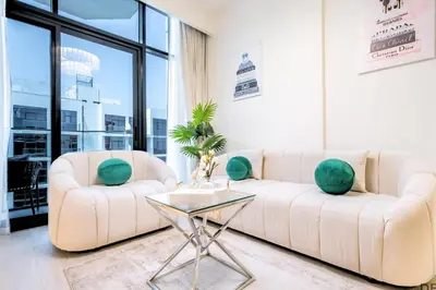 a living room with two white couches and a glass table at Vacay Lettings Charming Retreat Azizi Riviera in Dubai