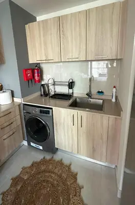 a kitchen with a sink and a washing machine at Stylish studio, center area, close to Burj Khalifa in Dubai