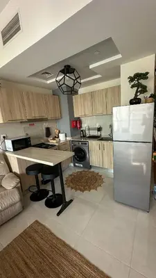 a kitchen with a white refrigerator and a table at Stylish studio, center area, close to Burj Khalifa in Dubai