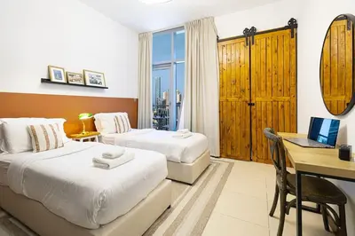 a bedroom with two beds and a desk with a laptop at 2BR on 30th Floor in JLT Near Metro & Walking Distance to JBR Beach, Dubai Marina in Dubai