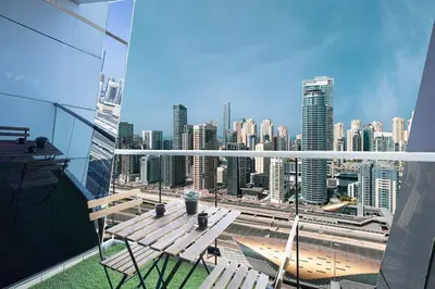 a balcony with a bench and a view of a city at 2BR on 30th Floor in JLT Near Metro & Walking Distance to JBR Beach, Dubai Marina in Dubai