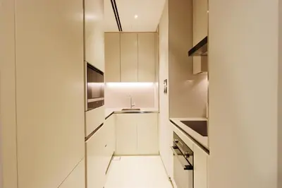 a small kitchen with white cabinets and a sink at 1BHK with Marina Views and Beach Access in Dubai