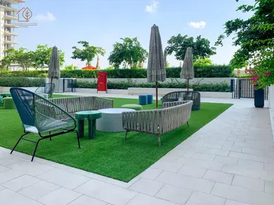 a patio with benches and a table and grass at Stylish Apartment with Golf Views in Dubai Hills 199GV-2 in Dubai