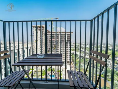 a table and two chairs on a balcony with a view at Stylish Apartment with Golf Views in Dubai Hills 199GV-2 in Dubai
